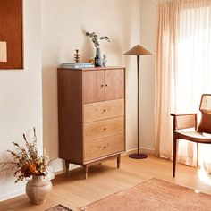 a living room with a dresser and chair