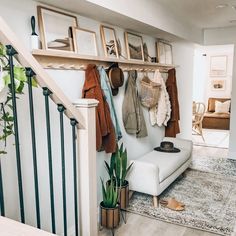 a white couch sitting under a wooden shelf next to a stair case