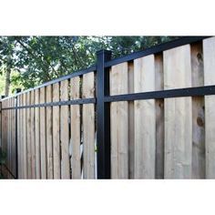 a wooden fence with black metal posts