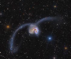 an object in the sky with stars around it and a blue ring at the center