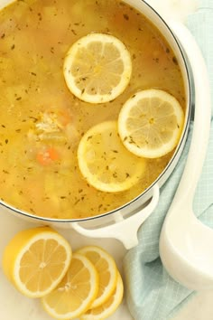 a pot filled with soup and sliced lemons