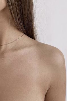 the back of a woman's shoulder with no shirt on, showing her breast