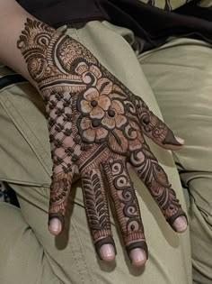 a woman's hand is decorated with hennap and flower designs on it