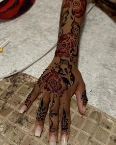 a woman's hand with hennap and flowers painted on her hands is shown