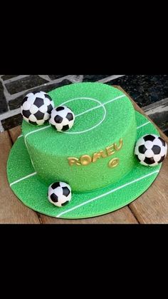 a green cake with soccer balls on it