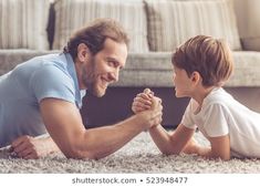 a father and son playing with each other on the floor