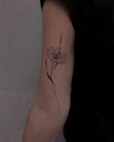 a black and white photo of a flower on the left arm, with one single flower in it