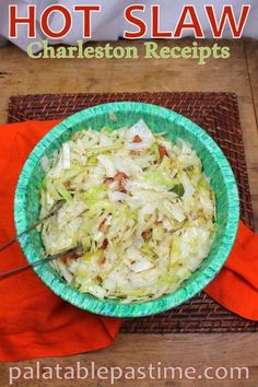 a green bowl filled with coleslaw on top of a wooden table next to an orange napkin