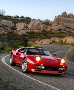 a red sports car driving down a winding road