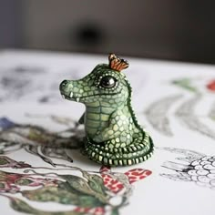 a small toy alligator with a butterfly on its head