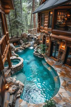 an outdoor swimming pool surrounded by stone steps and rocks, with a hot tub in the middle