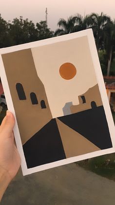 a person holding up a piece of paper with an image of a castle on it