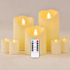 five lit candles with remote control in front of them