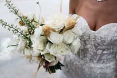 a bride holding a bouquet of white flowers