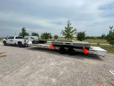 a white truck pulling a boat on the back of it's flatbed trailer