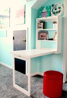 a white desk sitting in the corner of a room next to a red trash can