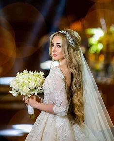 a woman in a wedding dress holding a bouquet of flowers