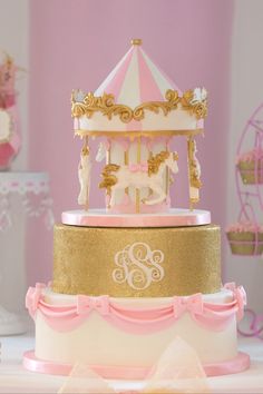 a three tiered carousel cake with pink and gold icing