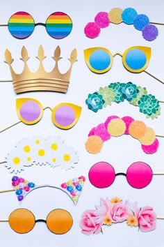 a group of different types of sunglasses and headbands on a white surface with flowers