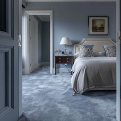 a bedroom with blue walls and carpeted flooring