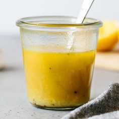 a glass jar filled with yellow liquid on top of a table