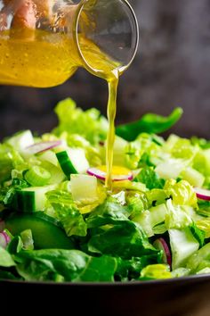 the dressing is being poured onto a salad