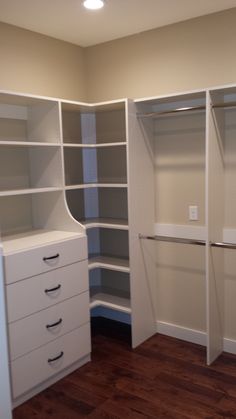 an empty closet is shown with white shelves and drawers on the bottom right hand side