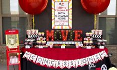 a movie themed birthday party with red balloons and black and white decorations on the table