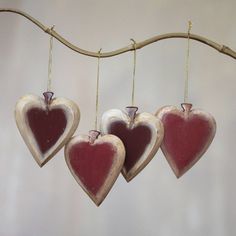 three heart shaped ornaments hanging from a branch