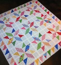 a quilted table topper with colorful triangles on it