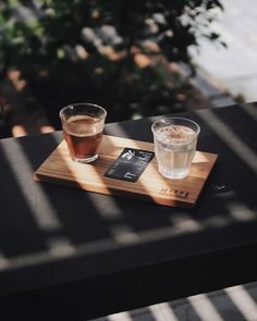 two glasses of tea sit on a wooden tray