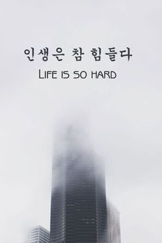 the words life is so hard are written in korean on top of a tall building