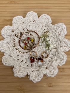 a crocheted doily with rings and beads on it