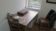 a wooden table sitting next to a window in a room