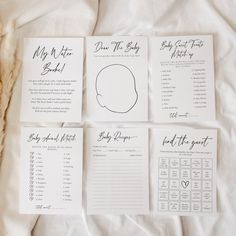 four baby shower games laid out on top of a white sheet with black ink and calligraphy