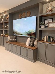 a large tv mounted to the side of a wall in a living room next to bookshelves