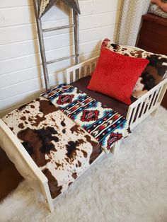 a white bed with brown and red pillows