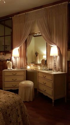 a bedroom with a vanity, mirror and stool