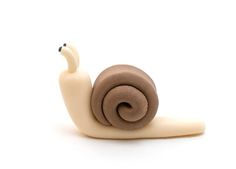 a snail figurine sitting on top of a white surface