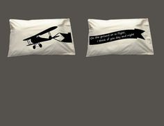 two pillow cases with an airplane and banner on the front, one is white and the other is black