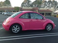 a pink car is parked in a parking lot