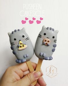 there are two cat shaped cake pops on a stick