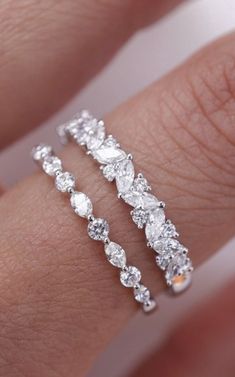 a woman's hand with two rings on it and one is wearing a diamond ring