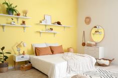 a bedroom with yellow walls and shelvings on the wall, including a bed