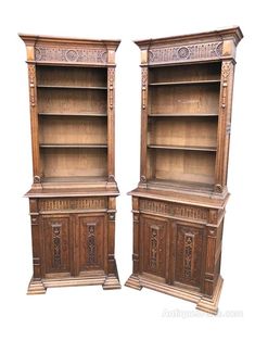 two wooden bookshelves sitting next to each other on top of a white background