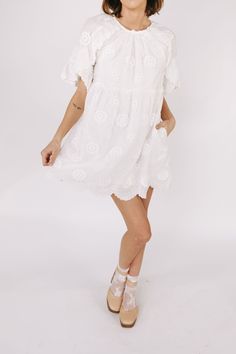 This white embroidered floral mini dress is the epitome of romantic elegance. Featuring a delicate scallop hemline and ruffle lace details, it is the perfect addition to any summer wardrobe. Enhance your feminine charm and steal hearts wherever you go with this beautiful dress. Details Round neckline Keyhole closure Ruffle lace details Embroidered fabricaiton Scallop hemline Lined Pockets Sizing Approximate measurements: SIZE LENGTH BUST WAIST Small 33” 36” 36” Medium 33” 38” 38” Large 34” 40” 40” Fabric has no stretch Model is 5’8” wearing small Material Self: 85% Tencel 15% NylonLining: 97% Polyester 3% Spandex Hand wash cold cold Do not bleachLay flat to dryFor best results dry clean Summer Brunch Dresses With Scalloped Edges, Feminine Lace Dress With Ruffles For Brunch, Lace Mini Dress With Scalloped Edges, Mini Lace Crochet Dress With Ruffles, Summer Wedding Lace Dress With Ruffle Hem, Spring Crochet Mini Dress With Lace Trim, Spring Crochet Dress With Lace Trim, Chic Floral Embroidered Mini Dress For Wedding, Summer Mini Dress With Ruffle Hem For Wedding