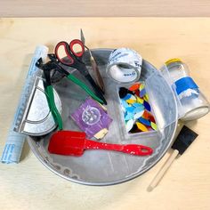 scissors, tape and other crafting supplies on a metal tray