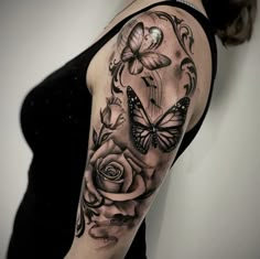 a woman with a butterfly and rose tattoo on her arm