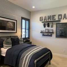 a bed room with a neatly made bed and some pictures on the wall above it