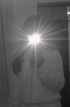 a person standing in front of a mirror with the sun shining through it's lens